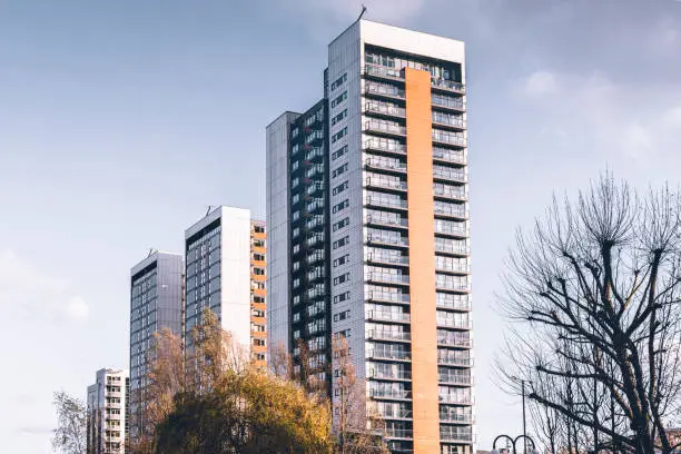 A group of tall buildings with trees in the background.